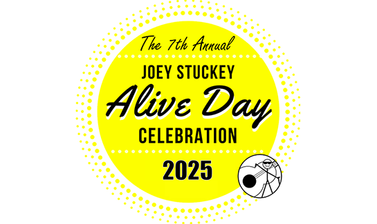The logo for the 7th Annual Joey Stuckey Alive Day Celebration. The logo is a bright yellow circle with black text. It also features Joey's stick figure avatar Blink.